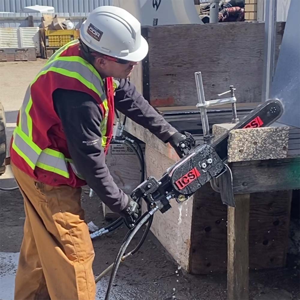 Clear View employee using the concrete chain saw to cut into a concrete block.