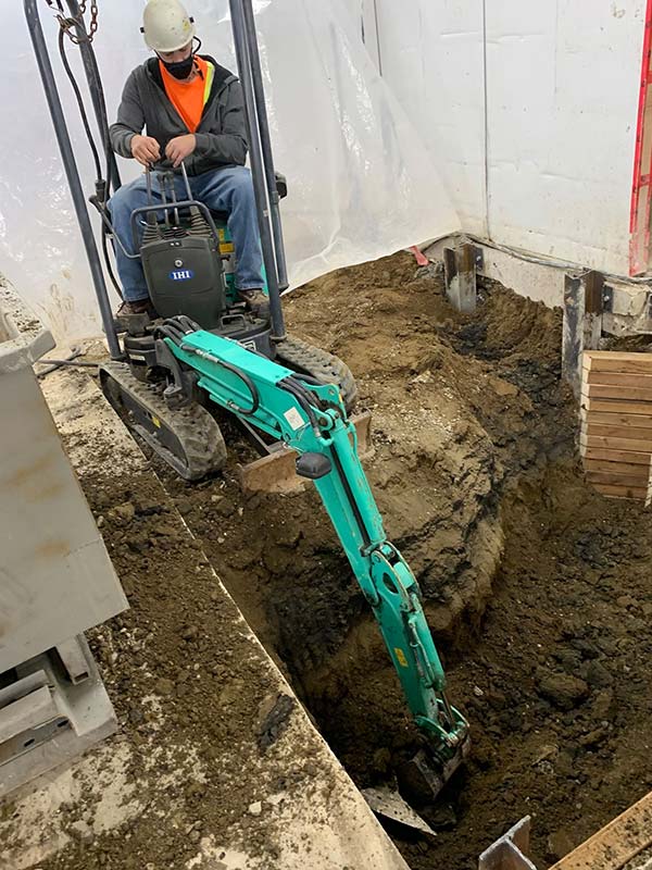A Clear View employee uses the electric mini excavator at a work site.